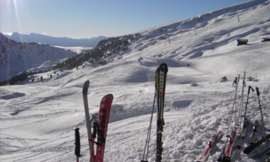 Ski stecken vor einem Bergpanorama aufrecht im Schnee