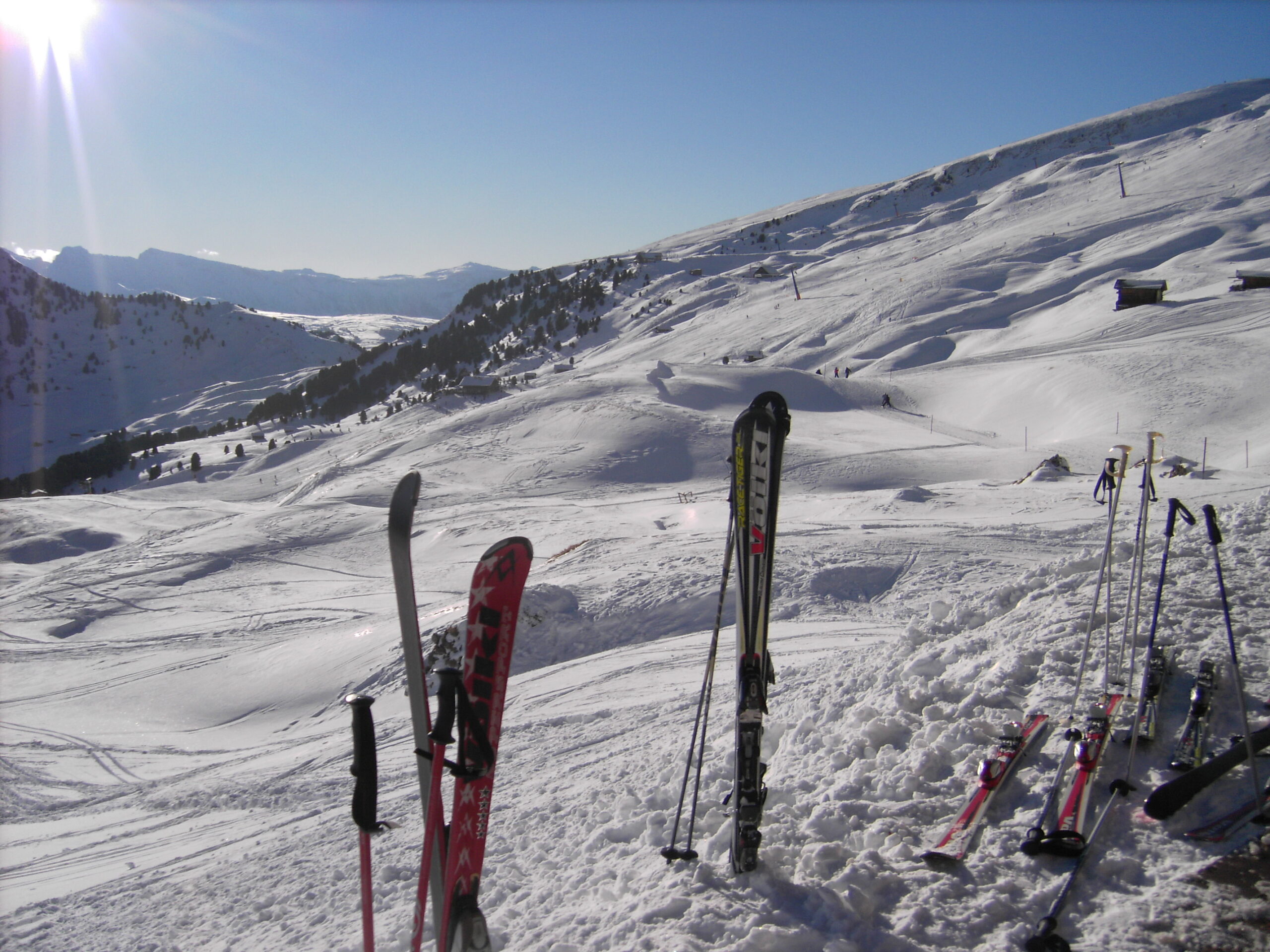Ski stecken vor einem Bergpanorama aufrecht im Schnee